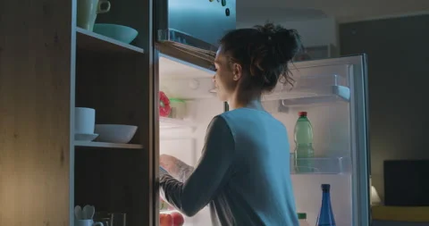 Woman having a midnight snack Stock Footage 202279896