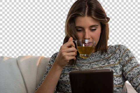 Woman having tea while using tablet Stock Photos