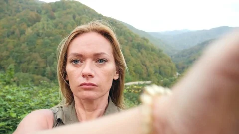 Woman having video chat using smartphone outdoors on a background of mountains Stock-Footage 80737325