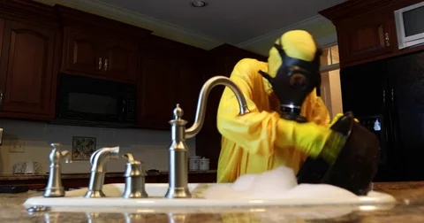 Woman in Haz Mat scrubbing pan Stock Footage