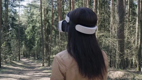 Woman in head-mounted display in the forest Stock Footage 74759370