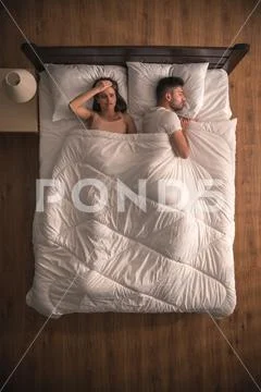 The woman with headache lie near the man. view from above Stock Photos