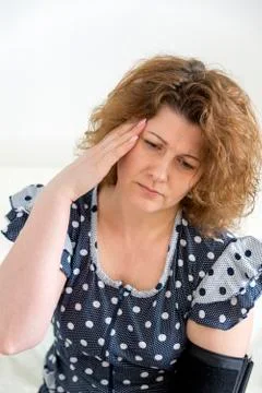 Woman with headache measures blood pressure Stock Photos