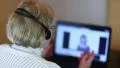Woman with headphones on computer talks to a client via computer HD Footage