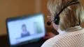 Woman with headphones with microphone on computer talking to customer HD Footage