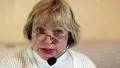 Woman with headphones with microphone looks at the camera and talks to a client HD Footage