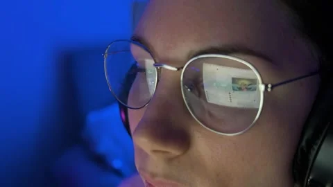 Woman with a headset looking at a computer screen and scrolling Internet pages 스톡 동영상 243846436