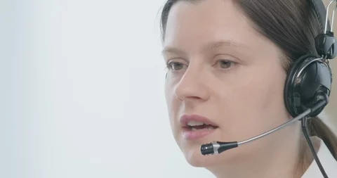 Woman in headset talking to a client Stock Footage 129774101