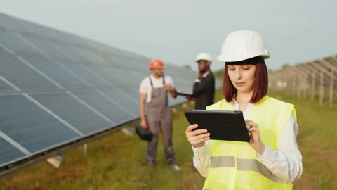 Woman in helmet using digital tablet for work on solar station. African american Stock Footage 168586988