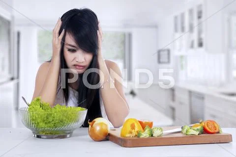 Woman hesitate to eat salad Stock Photos