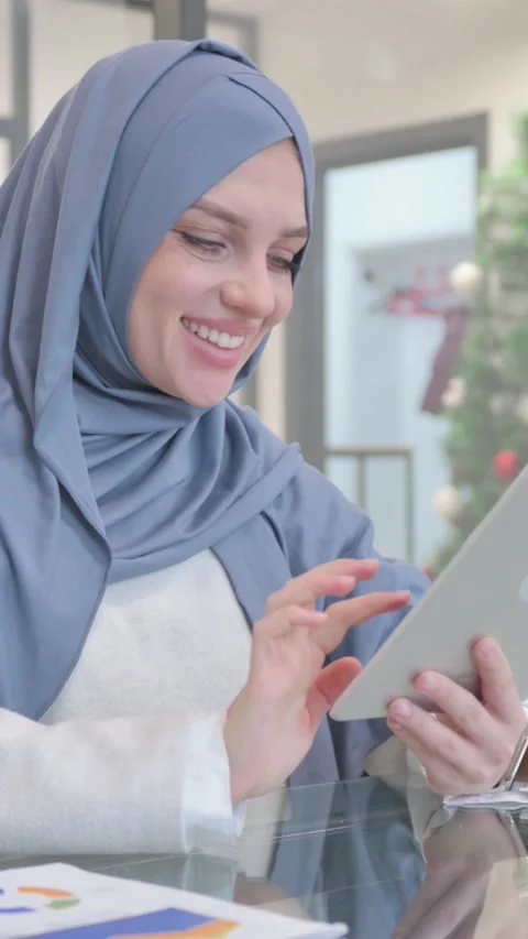 Woman in Hijab Celebrating while Using Tablet, vertical video Stock Footage 324783496