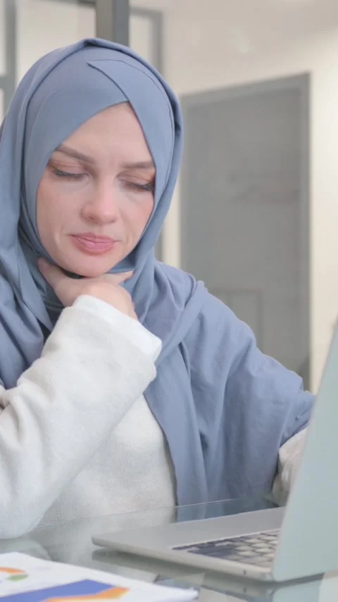Woman in Hijab Coughing while Using Laptop, vertical video Stock Footage 324782632