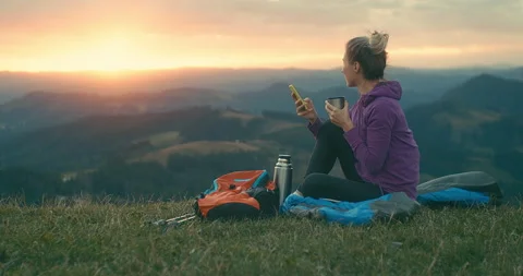 Woman hiker, backpacker traveler with her phone camera on the top of mountain Stock Footage