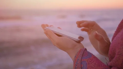Woman hold and using mobile on seascape background with flare light . Stock Footage 76961213