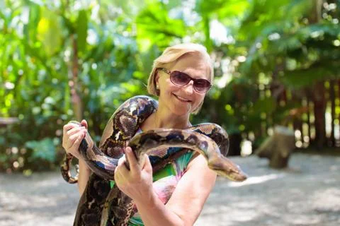 Woman hold python snake at zoo. Photos