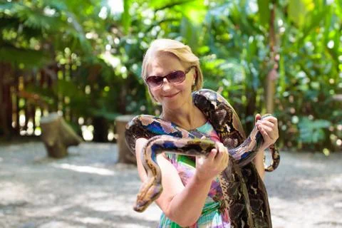Woman hold python snake at zoo. Photos