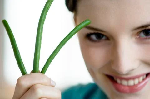 Woman holding 3 string beans, close-up Stock Photos