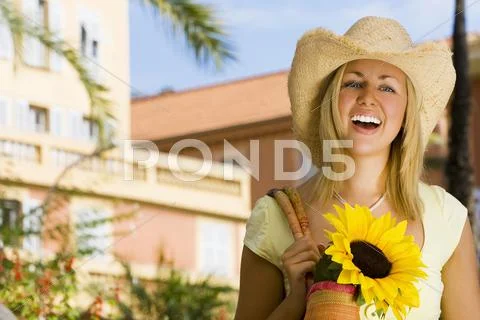 Woman holding bag of sunflowers smiling in summer Stock Photos