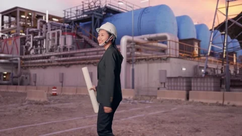 Woman Holding Blueprint While Walking and Looking Around at Gas Plant Stock Footage 337759793