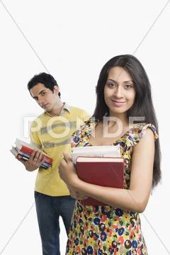Woman holding books with boyfriend standing behind her Stock Photos