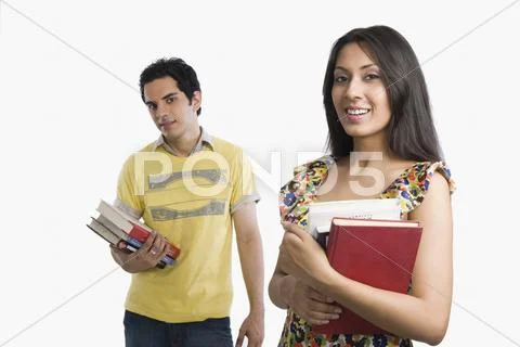 Woman holding books with boyfriend standing behind her Stock Photos