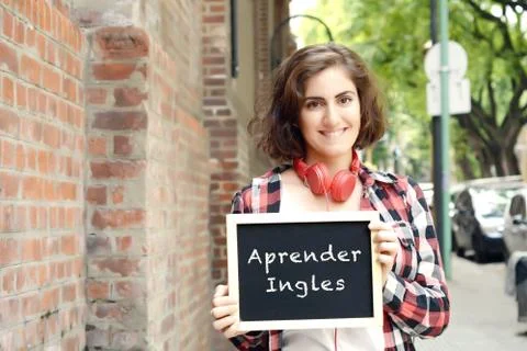 Woman holding chalkboard with "aprender ingles". Stock Photos