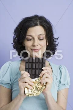 A woman holding a chocolate bar, Stock Photos
