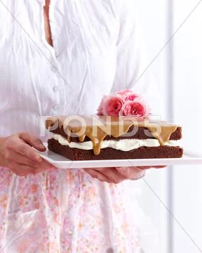 Woman Holding Chocolate Sponge Coffee Cake Decorated With Flowers