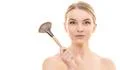 The woman holding a cosmetic brush on the white background Photo