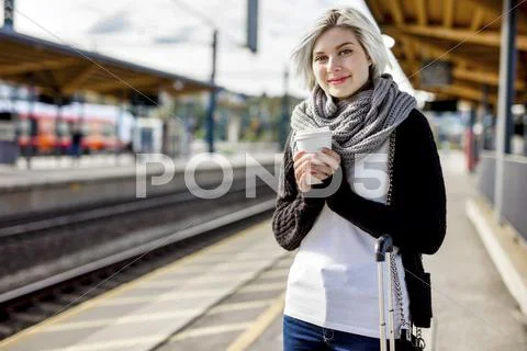 Woman Holding Disposable Coffee Cup At Train Station Stock Photos