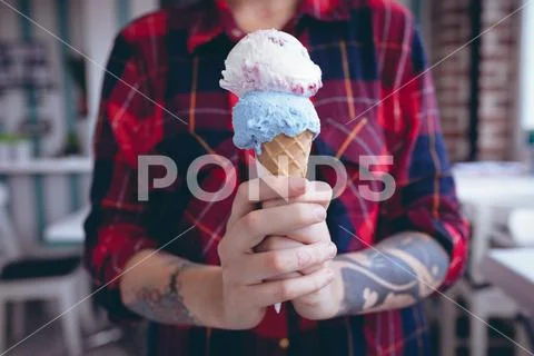 Woman holding a double scoop ice-cream ~ Premium Photo #82933909