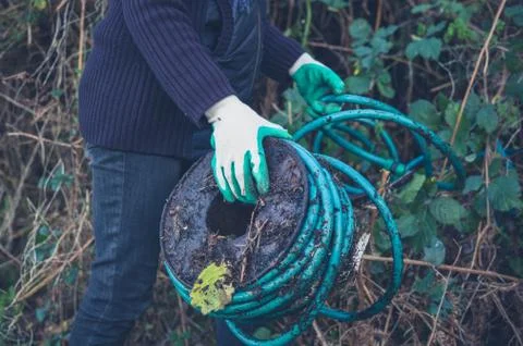 Woman holding garden hose Fotos Stock