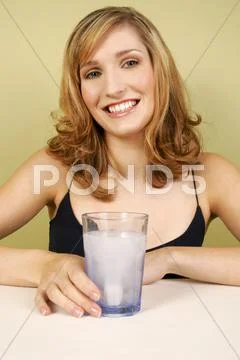 A woman holding a glass of water. Stock Photos