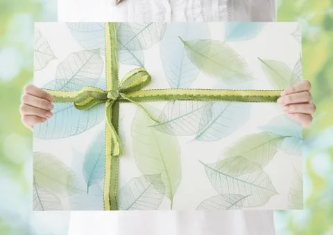 Woman holding a leaf pattern panel with ribbon Foto stock