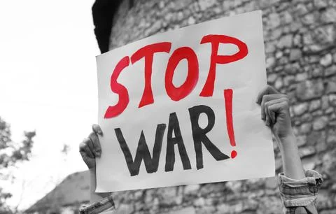 Woman holding poster with words Stop War against brick wall outdoors, closeup Stock Photos