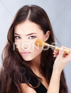 Woman holding powder brush Stock Photos