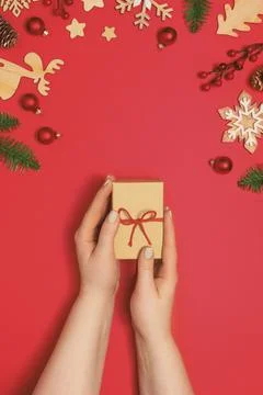 Woman holding present box on red background Stock Photos