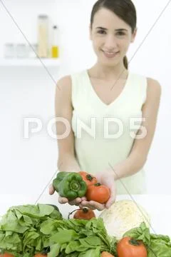 Woman Holding Ripe Tomatoes And Bell Pepper, Assorted Vegetables In Foreground,