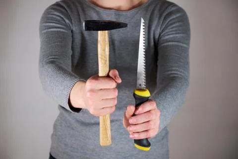Woman holding saw and hammer Stock Photos
