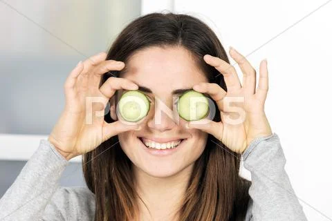 Woman holding slice of cucumber Stock Photos