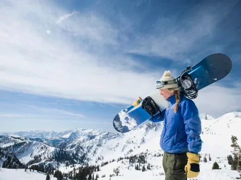 Woman holding snowboard, Wasatch Mountains, Utah, United States Stock Photos