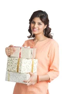 Woman holding a stack of gift boxes and smiling Фото