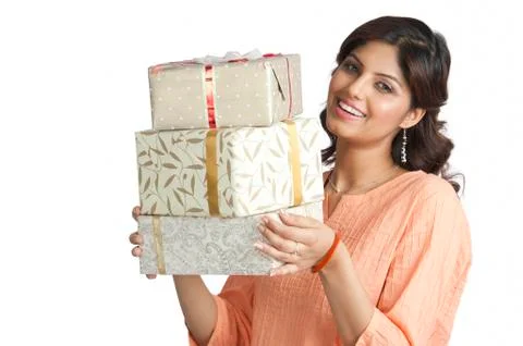 Woman holding a stack of gift boxes and smiling Stock Photos