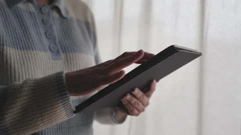 Woman holding a tablet browsing the internet or interacting with an app. Woma Stock Footage 148348734