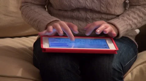Woman holding a tablet computer on her lap, typing a message, email Stock Footage 33796962