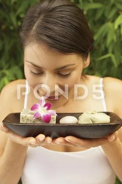 Woman holding tray smelling flower Stock Photos