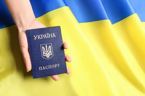 Woman holding Ukrainian internal passport on national flag, closeup with spac Stock Photos