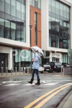 Woman Holding Umbrella And Crossing Street
