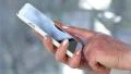 Woman holding a white cell phone. Woman looking the photos in her smartphone HD Footage
