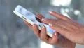 Woman holding a white cell phone. Woman looking the photos in her smartphone HD Footage